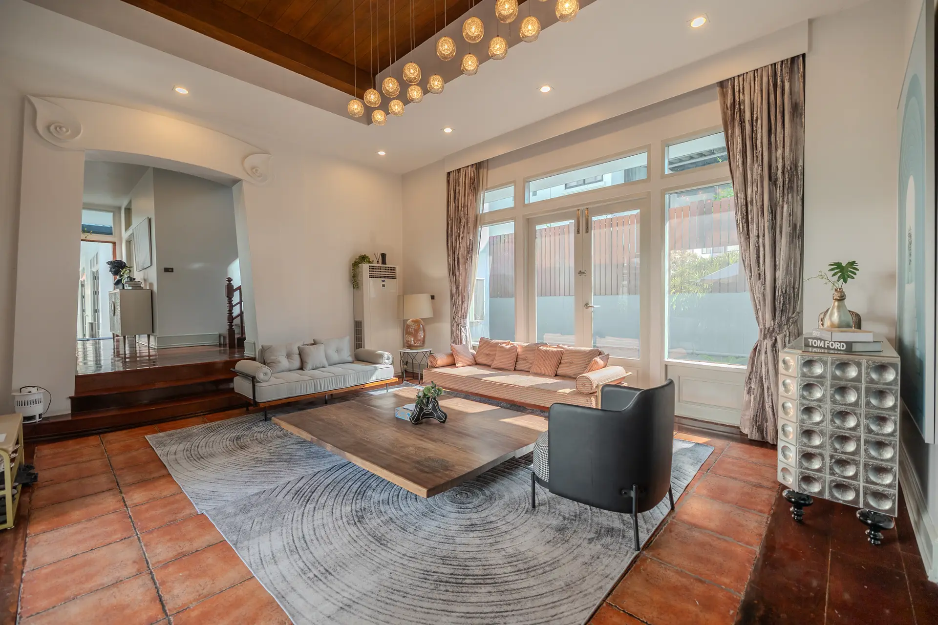 Living room with sofas, wooden floors and tall windows at Villa Oasis