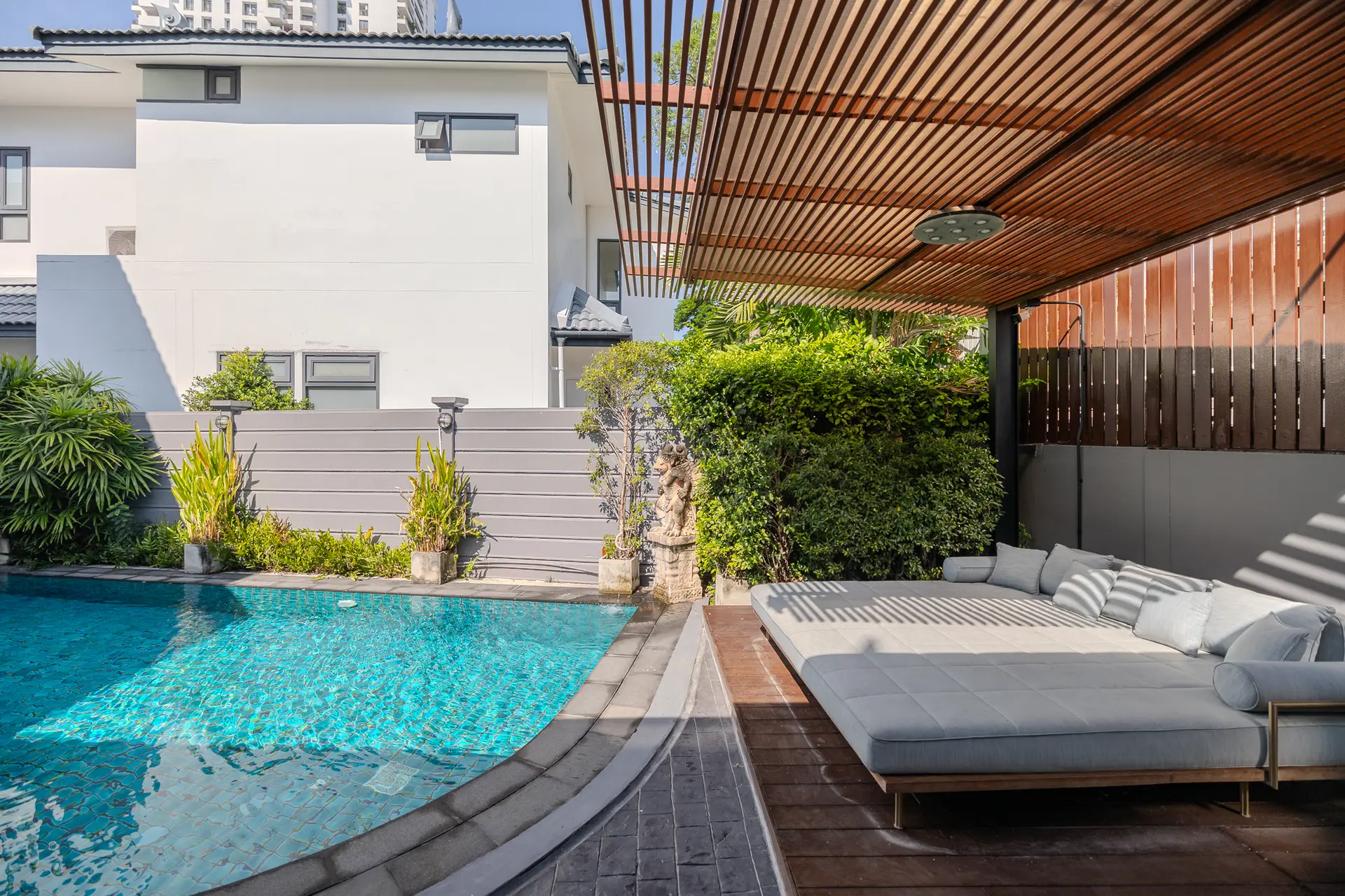 Daybed beside the private pool under a timber pergola at Villa Oasis