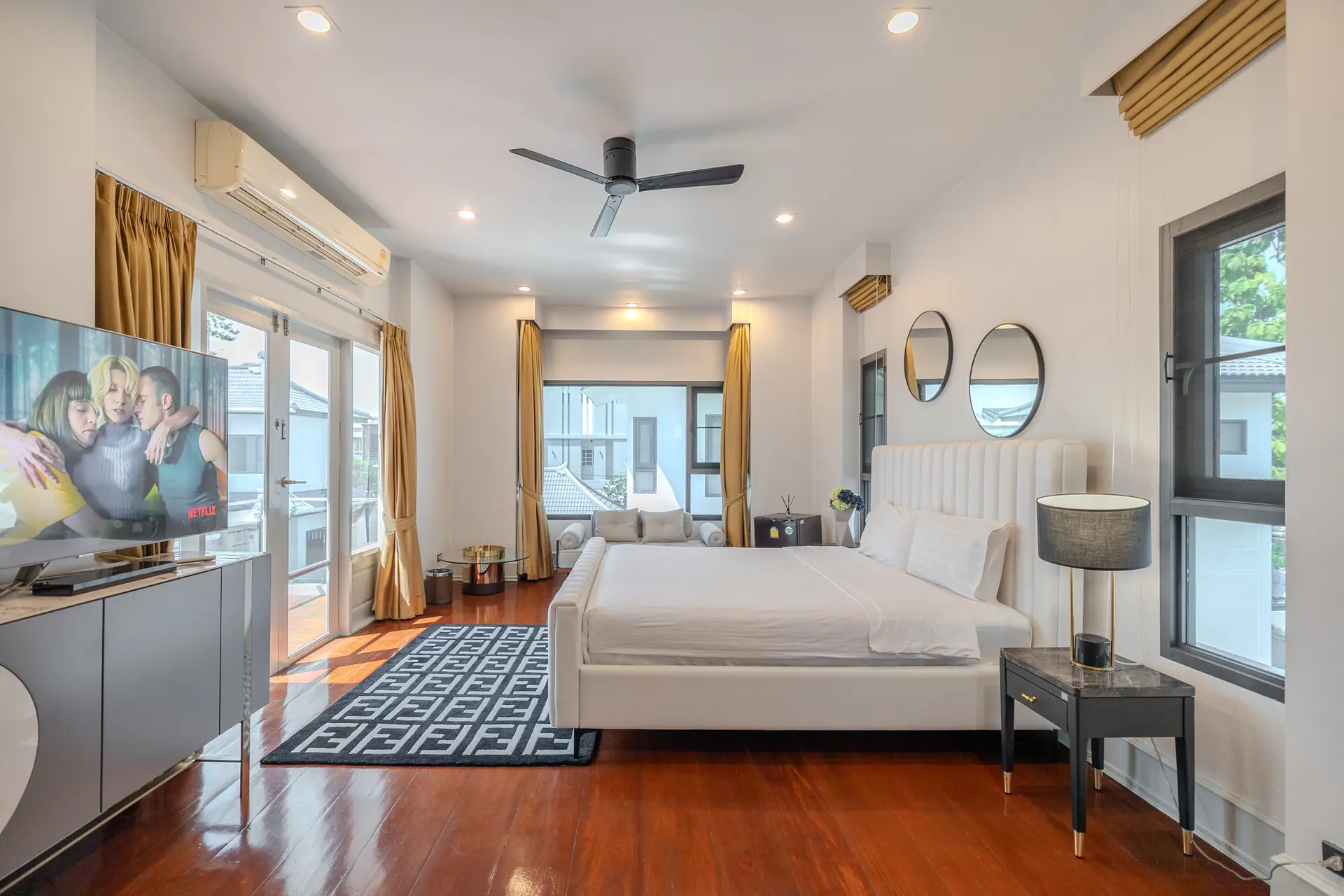 Bedroom with a white upholstered bed and balcony doors at Villa Oasis