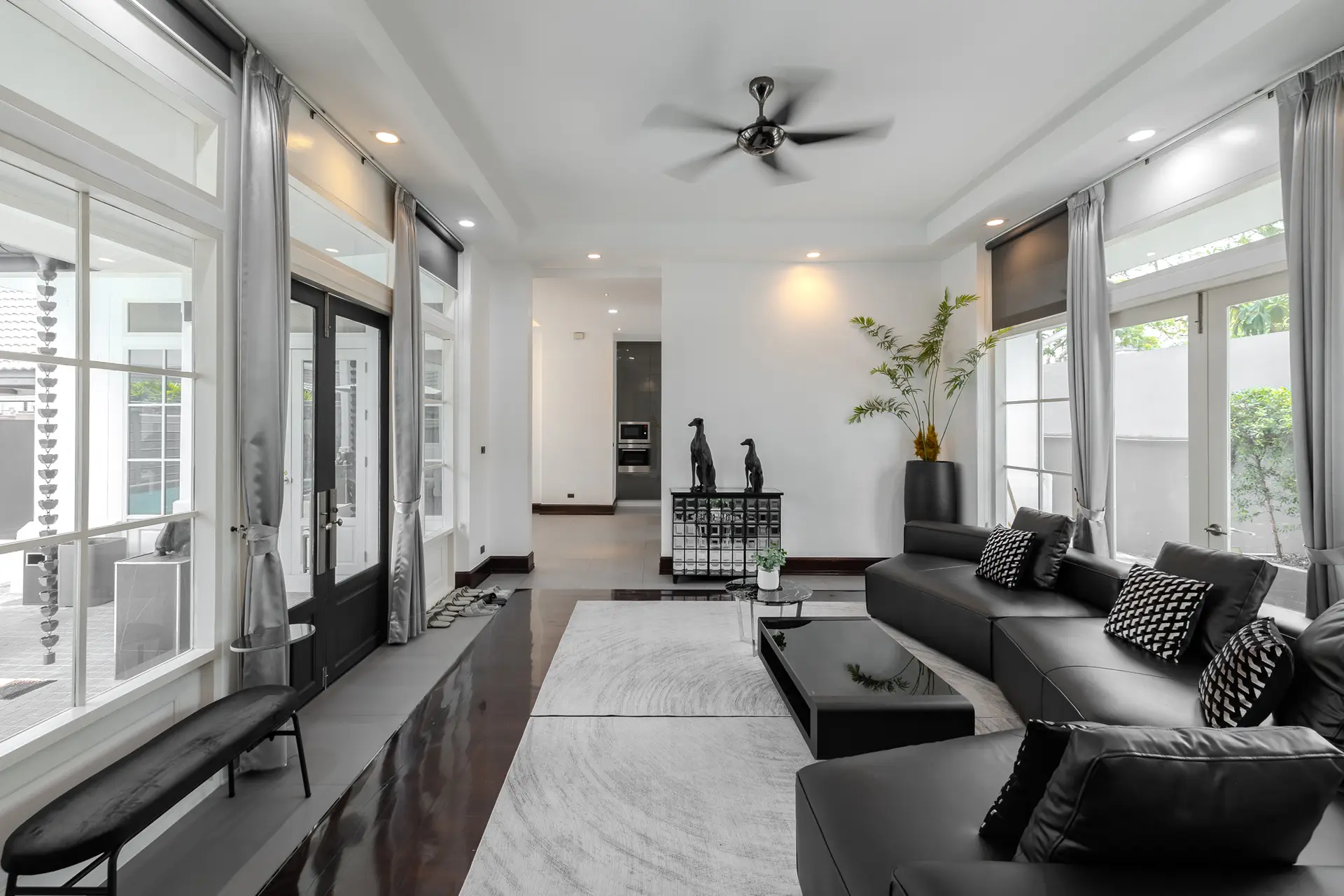 Living room with a large black sectional sofa at Villa Noir