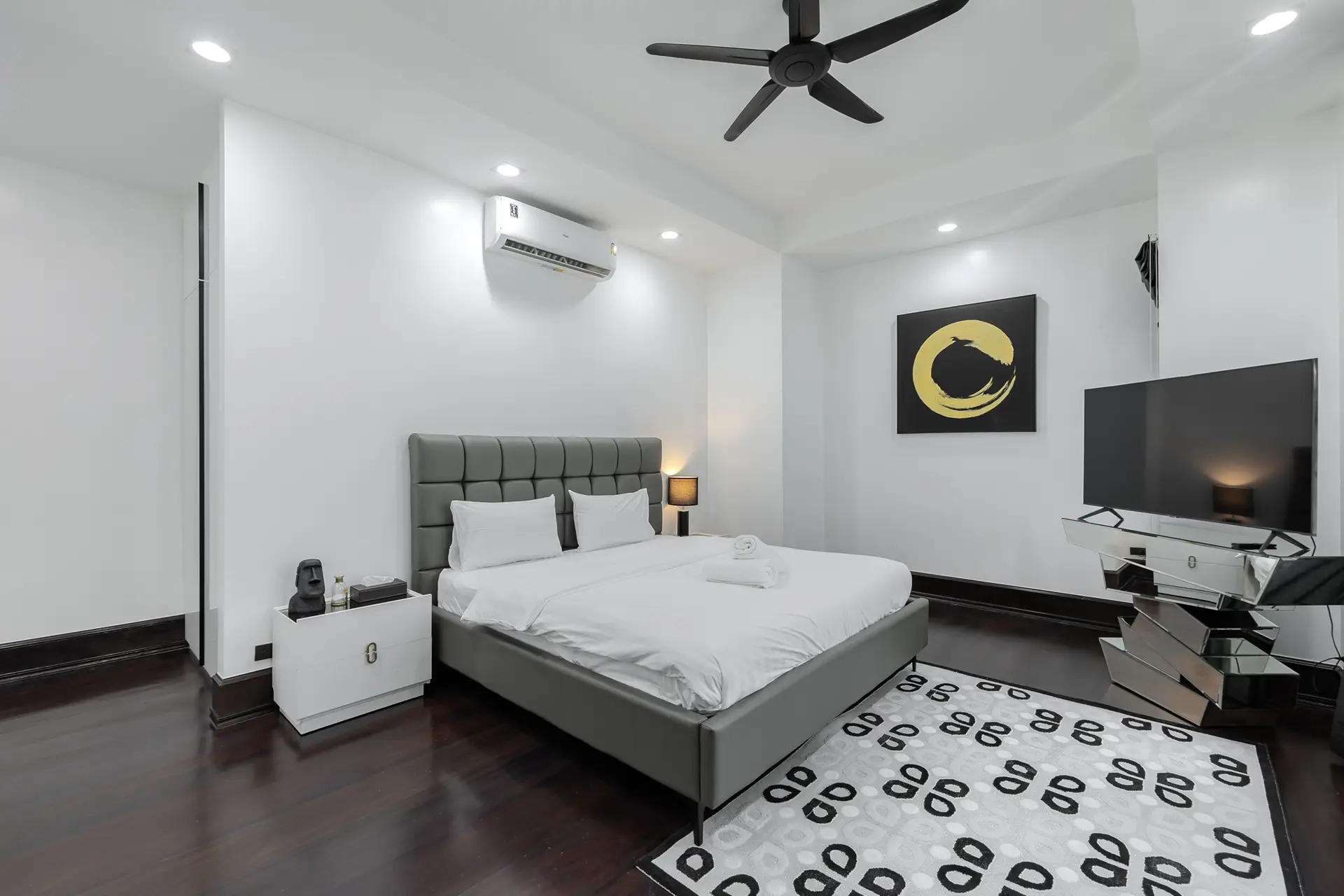 Bedroom with a grey upholstered bed at Villa Noir