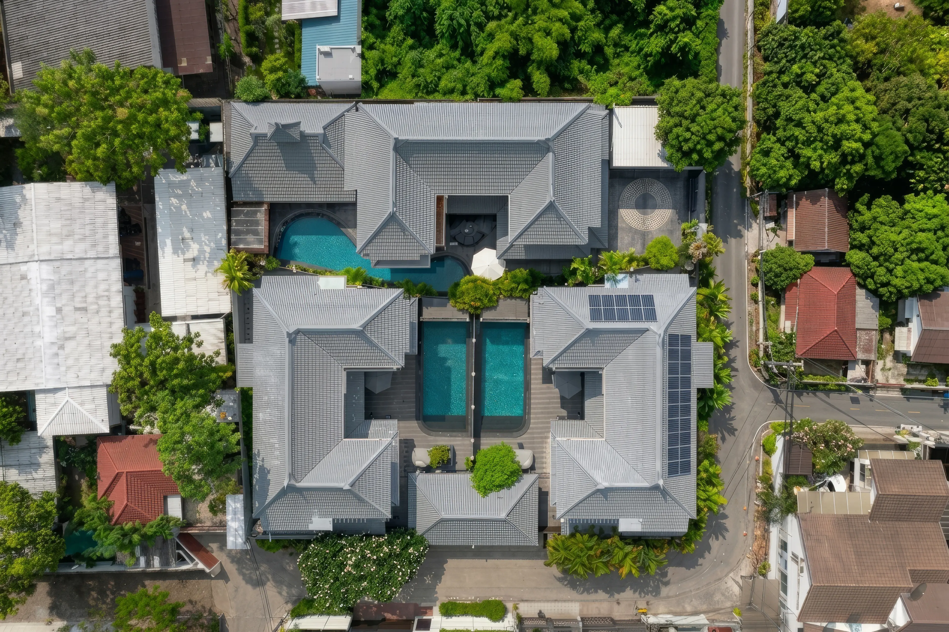 Aerial view straight down on the villa compound in Thong Lo, Bangkok: three large houses around a courtyard with private swimming pools